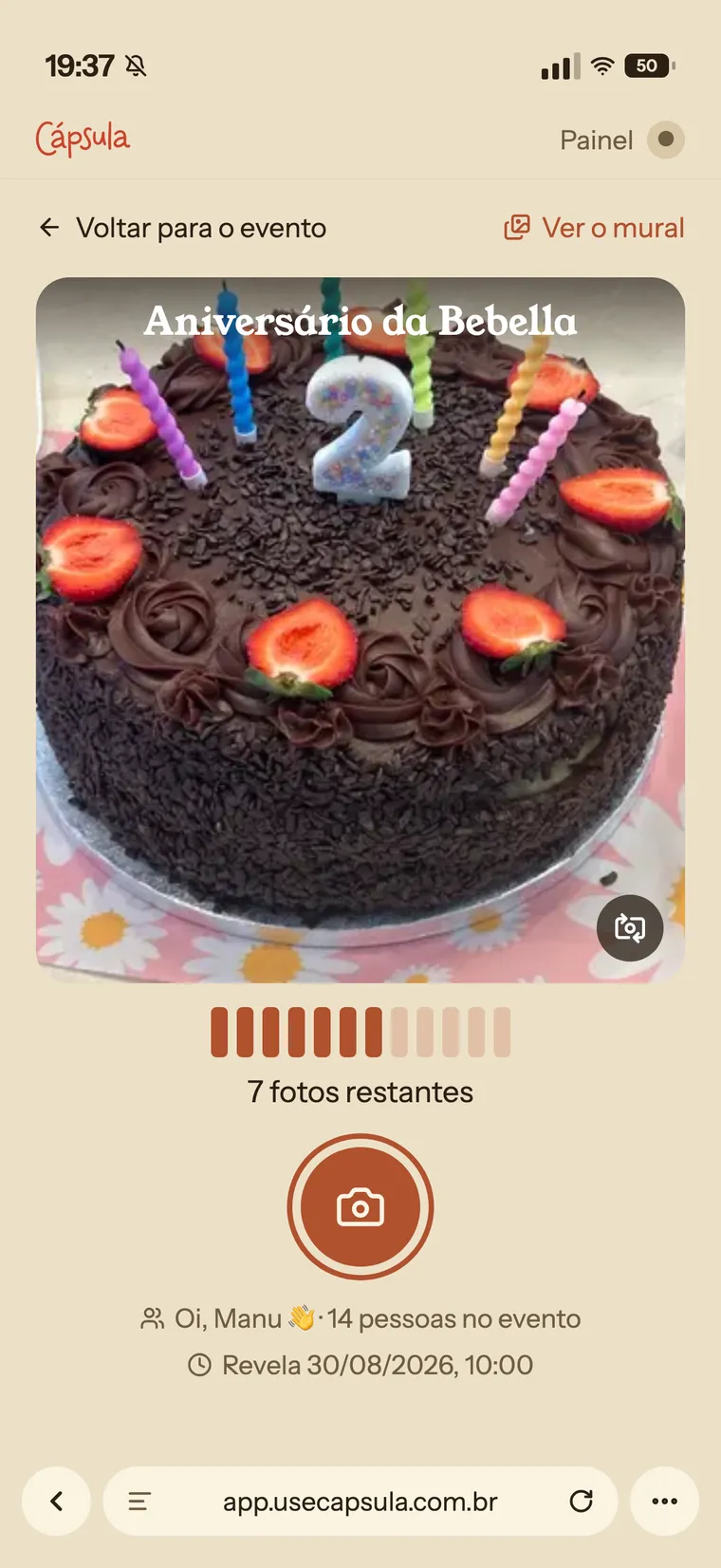 Tela da câmera no celular: o visor apontado para o bolo de aniversário, as poses restantes, o botão de disparo e a barra de endereço do navegador visível embaixo
