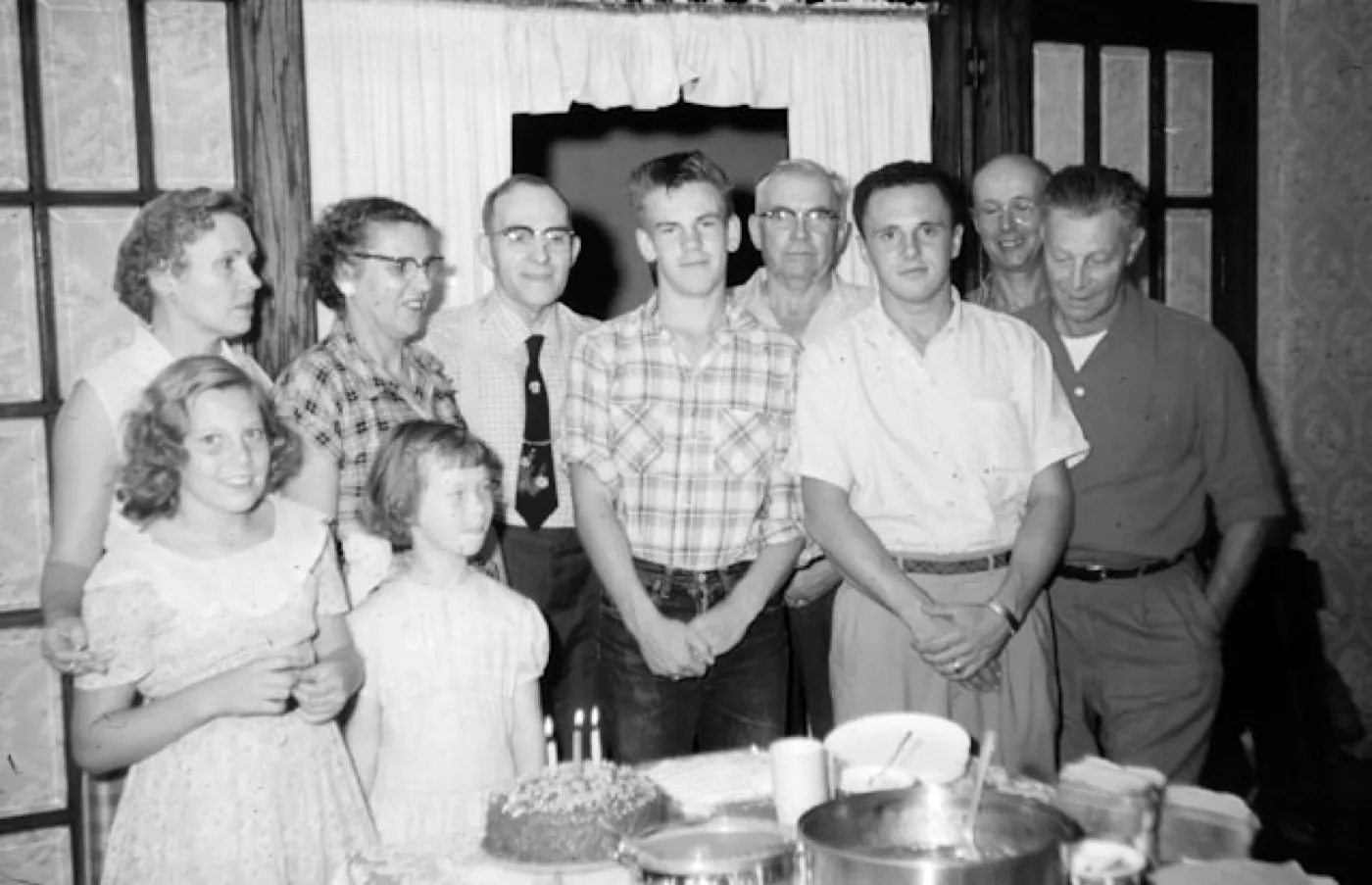 A mesma foto de família em volta do bolo, revelada na câmera Preto & Branco: sem cor, com sombras marcadas.