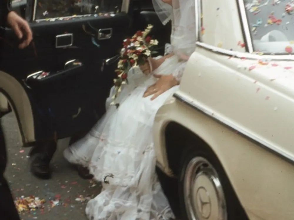Casamento: noiva entrando num carro antigo com o buquê na mão, confete espalhado pelo chão